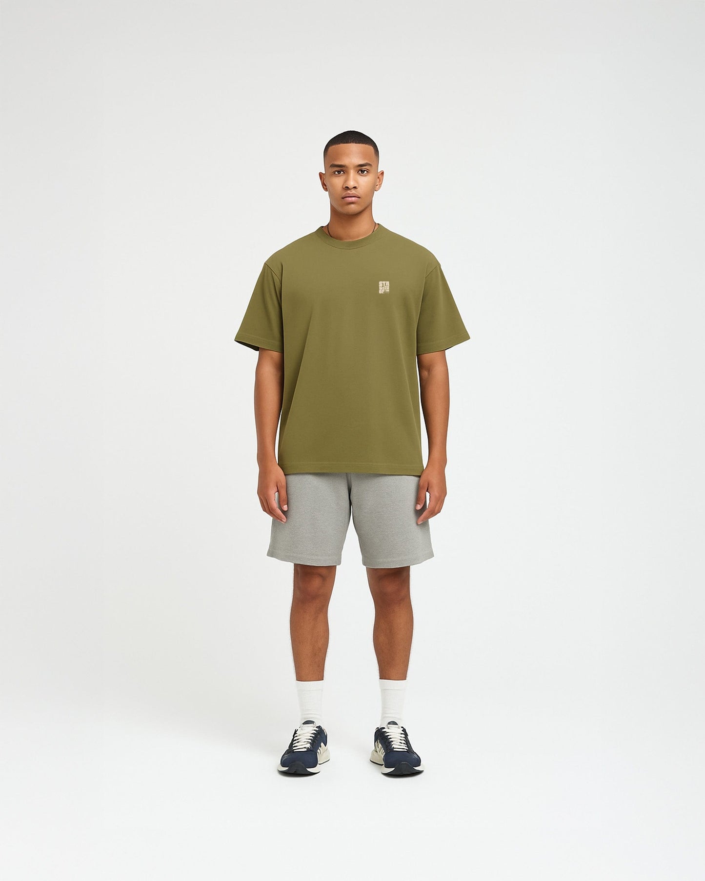 Model draagt een olijfgroen oversized T-shirt van 1cultuur met op de borst de quote “Sta weer op” in kleine witte letters, streetwear geïnspireerd design.